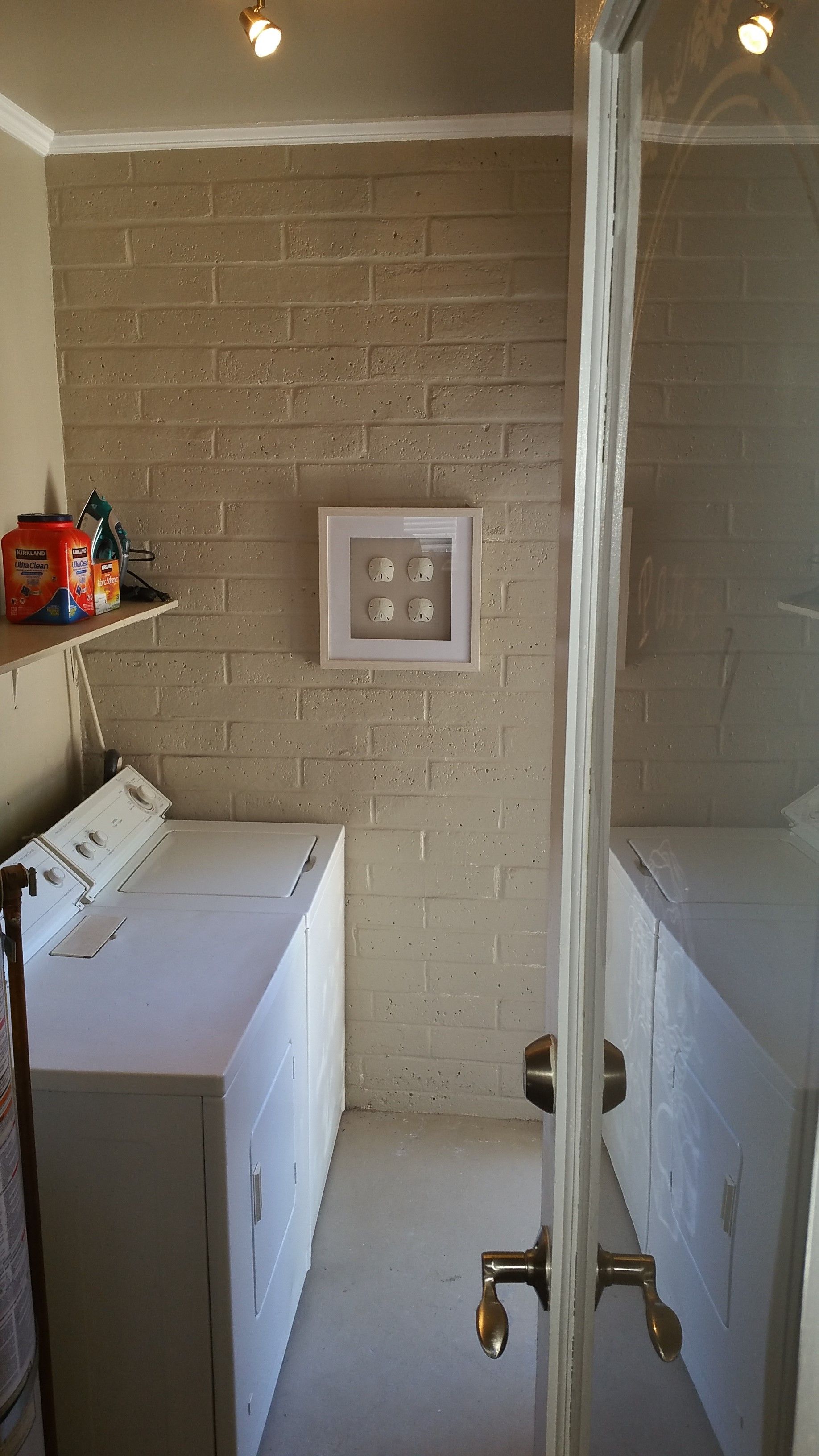 Bathroom with two white vanities, a central wall light switch, and a glass shower door.