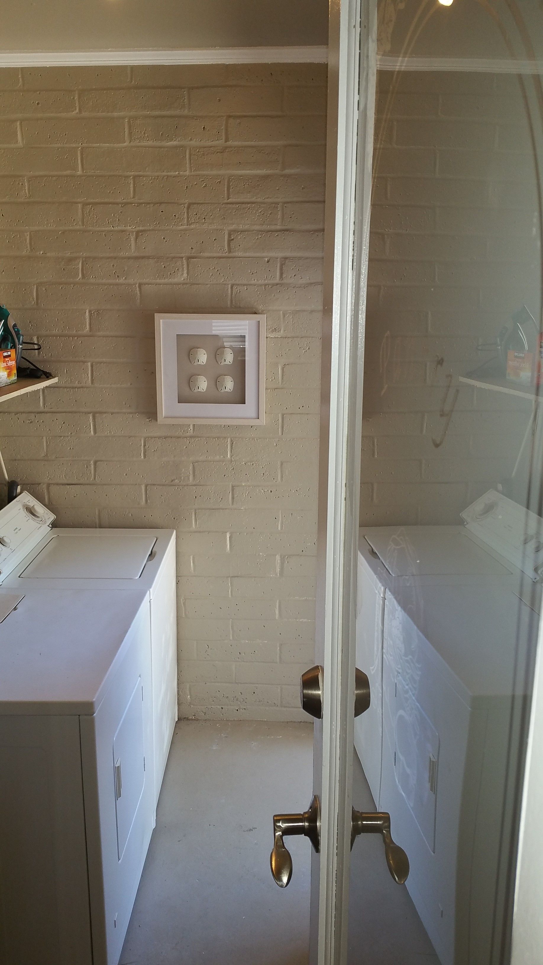 Small bathroom with a glass shower door, white sink cabinet, and beige tiled walls.