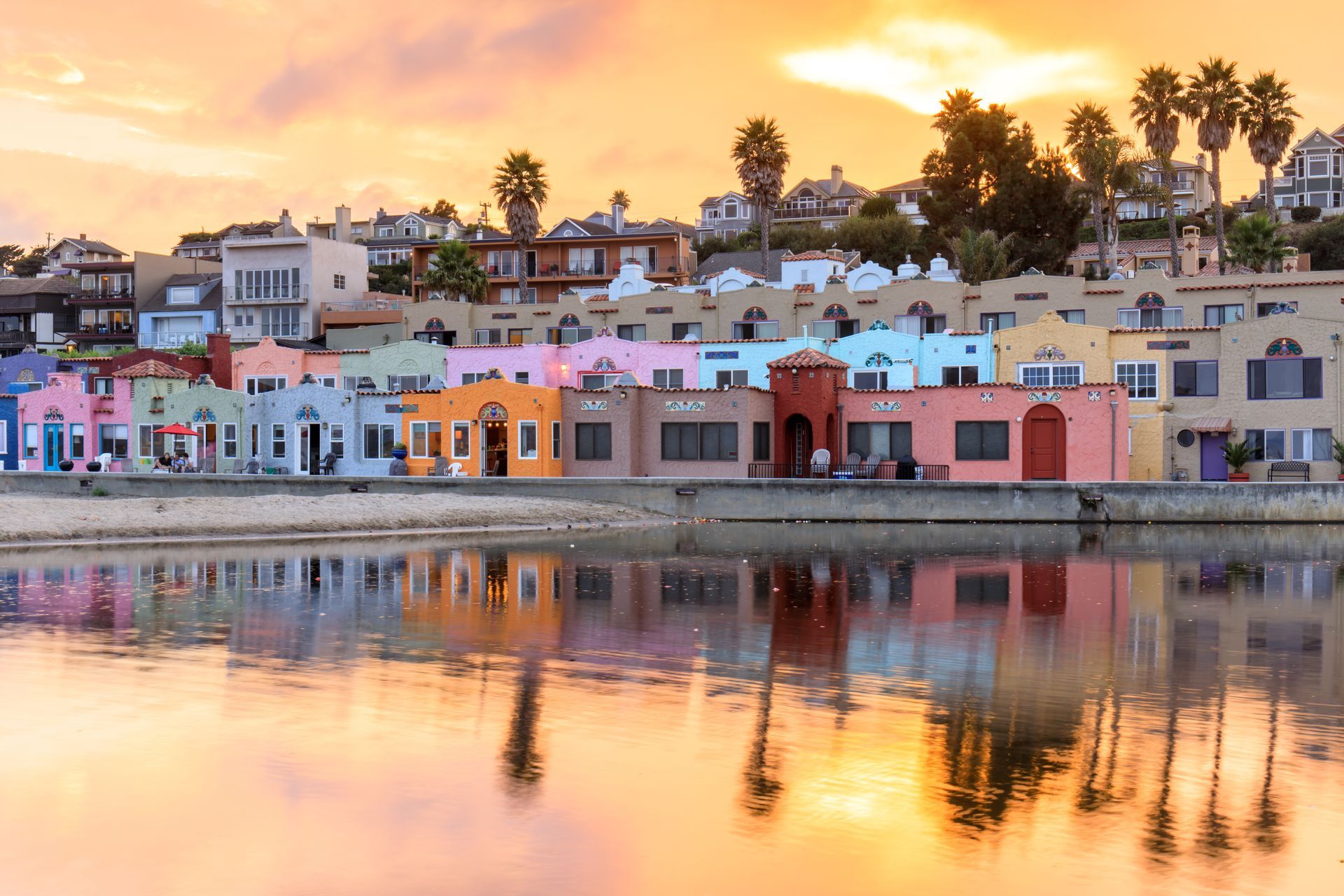 Colorful seaside houses at sunset reflected in calm water