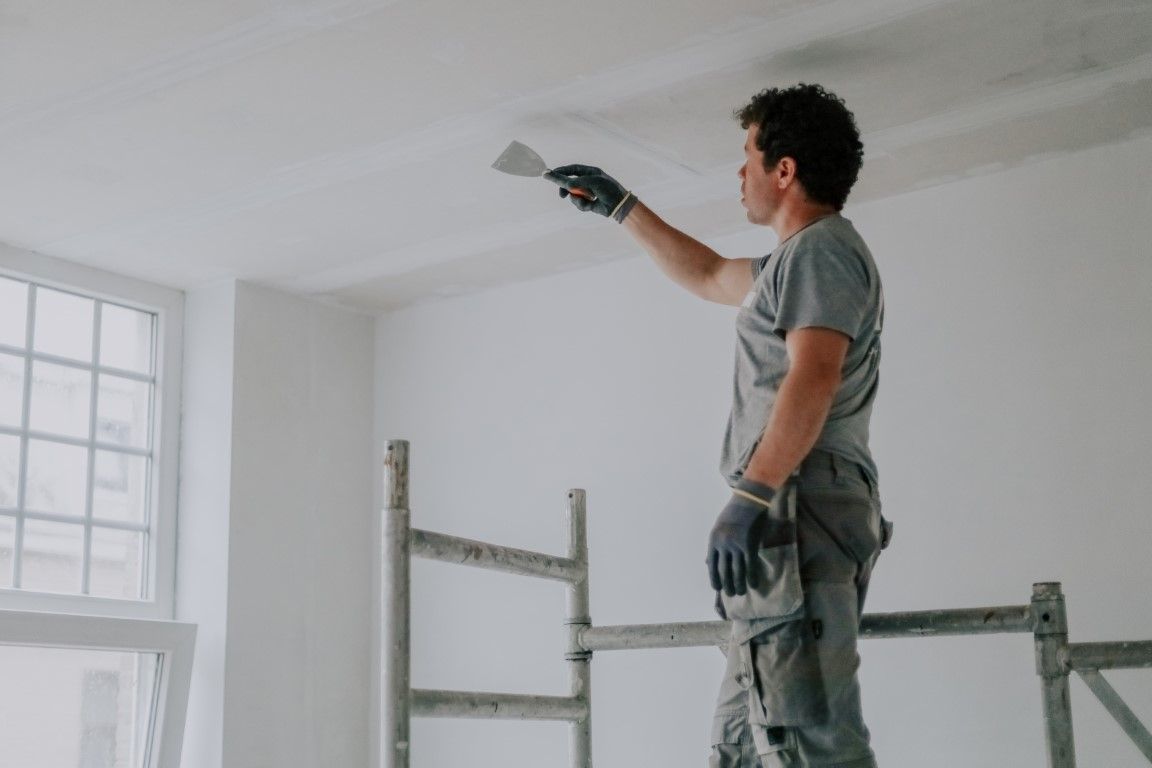 Close up of scraping off old popcorn ceiling texture.