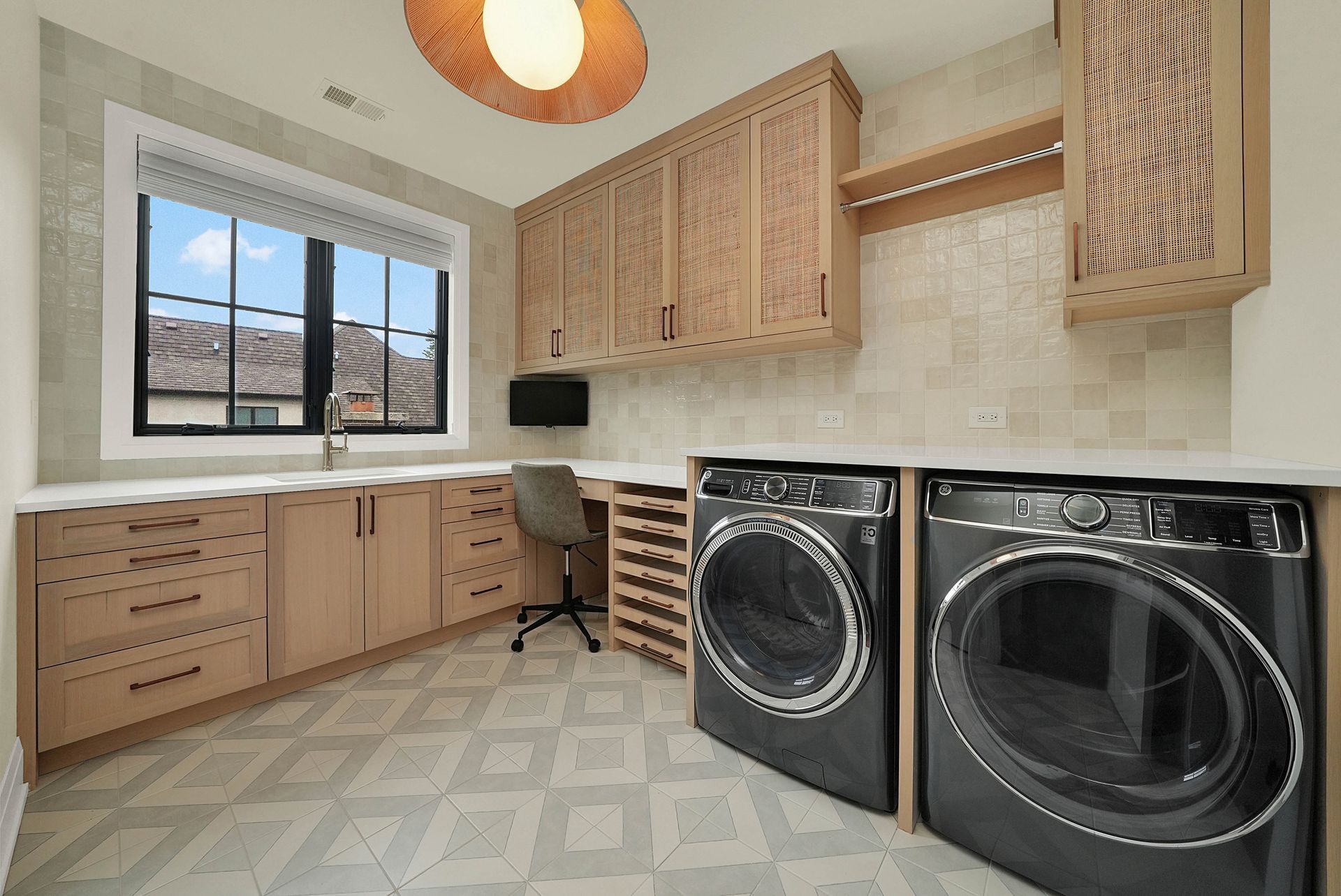Laundry room with wood cabinets, front-loading washer and dryer, and a window overlooking mountains