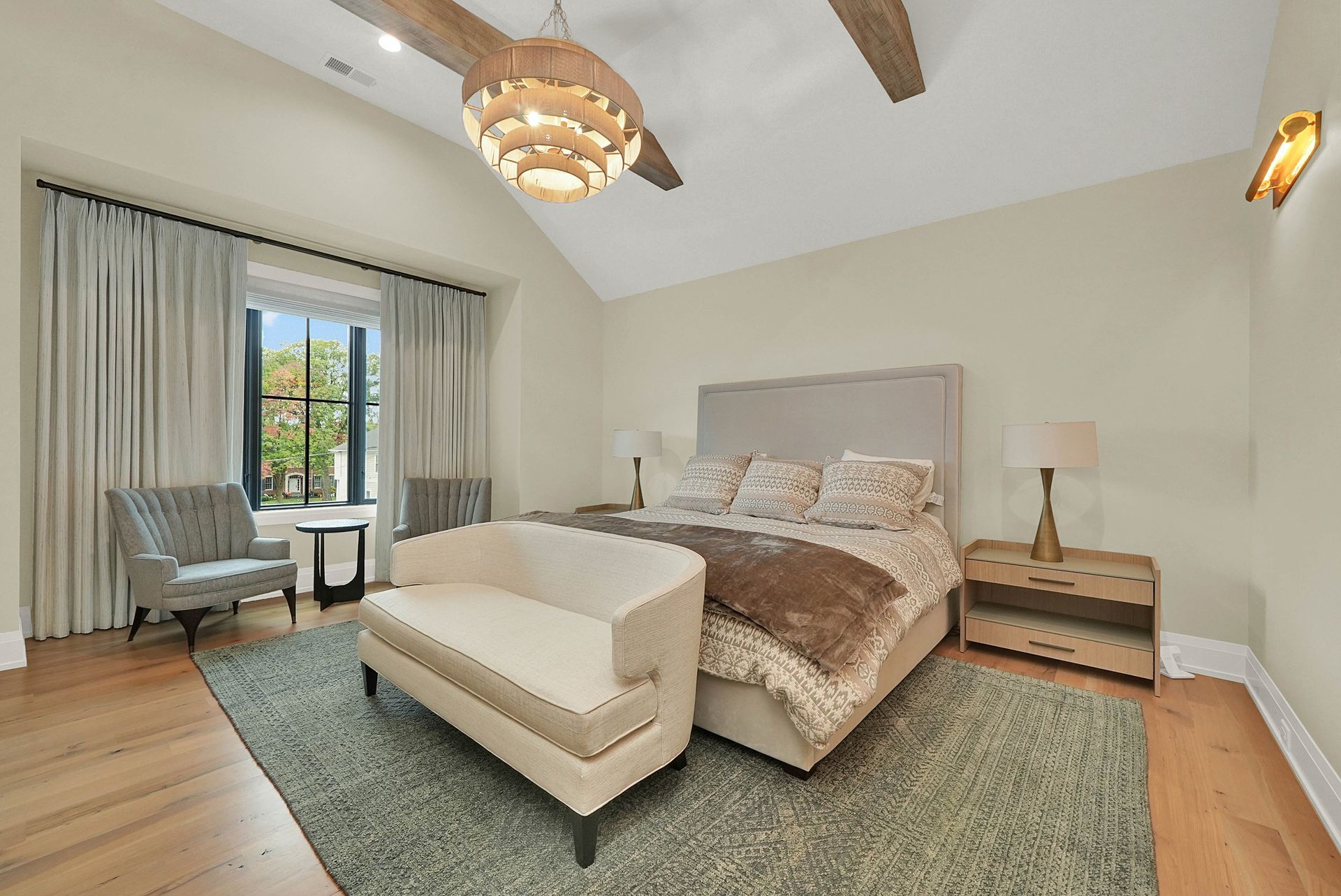 Bright bedroom with a bed, nightstand, chair, chandelier, and sliding glass doors to a balcony