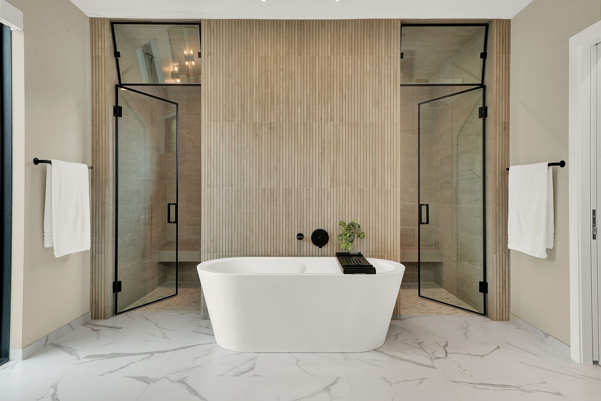 Modern bathroom with freestanding tub, glass showers, and marble flooring