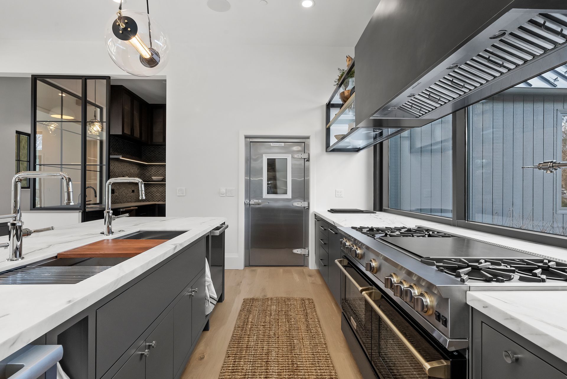 Modern kitchen with white countertops, gray cabinets, stainless steel appliances, and island seating
