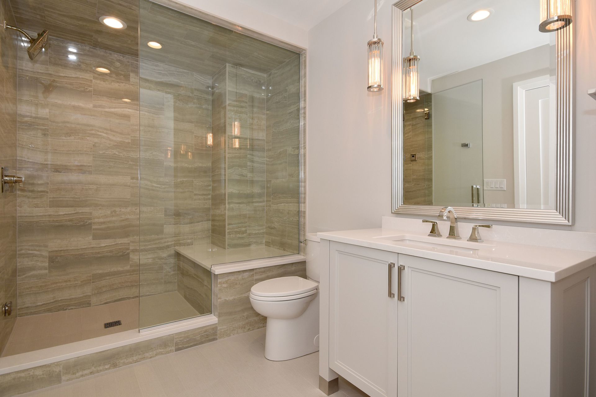 Modern bathroom with glass-enclosed shower, white vanity, and large wall mirror