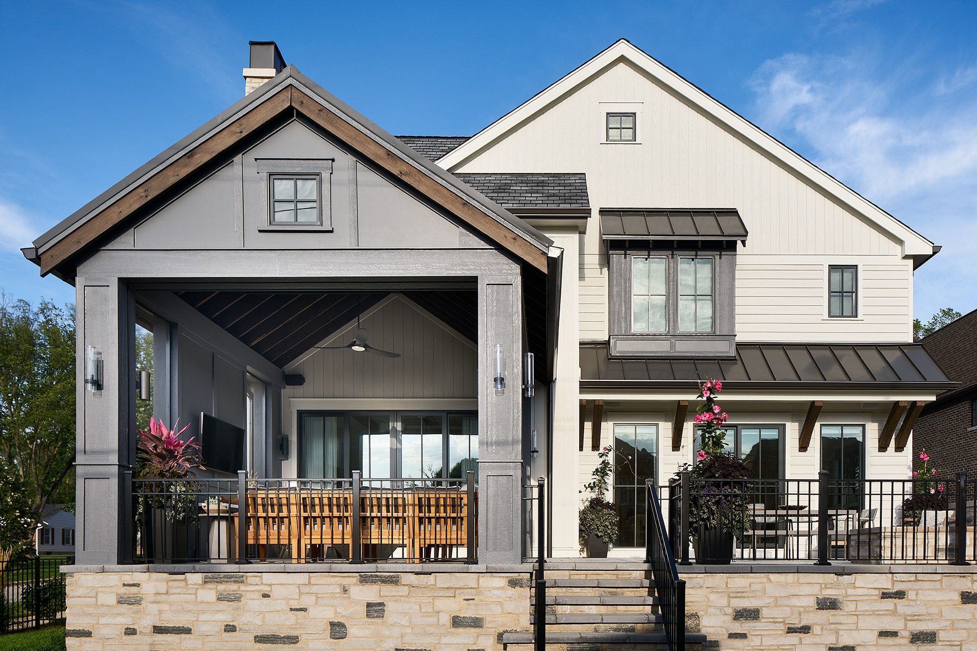 Modern two-story house with a covered front porch, white siding, and stone accents