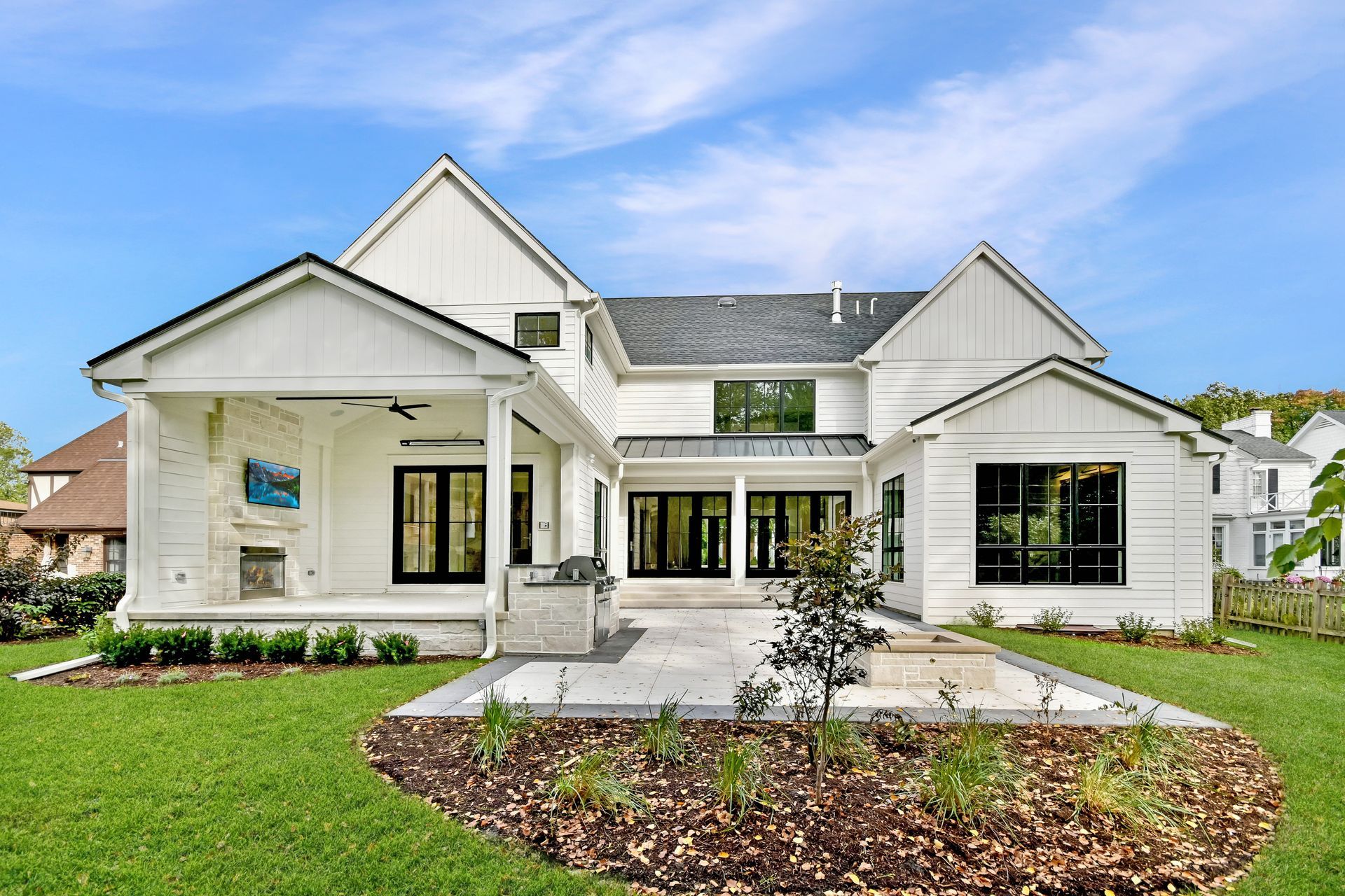 Modern white single-story house with a gabled roof, front porch, and landscaped yard