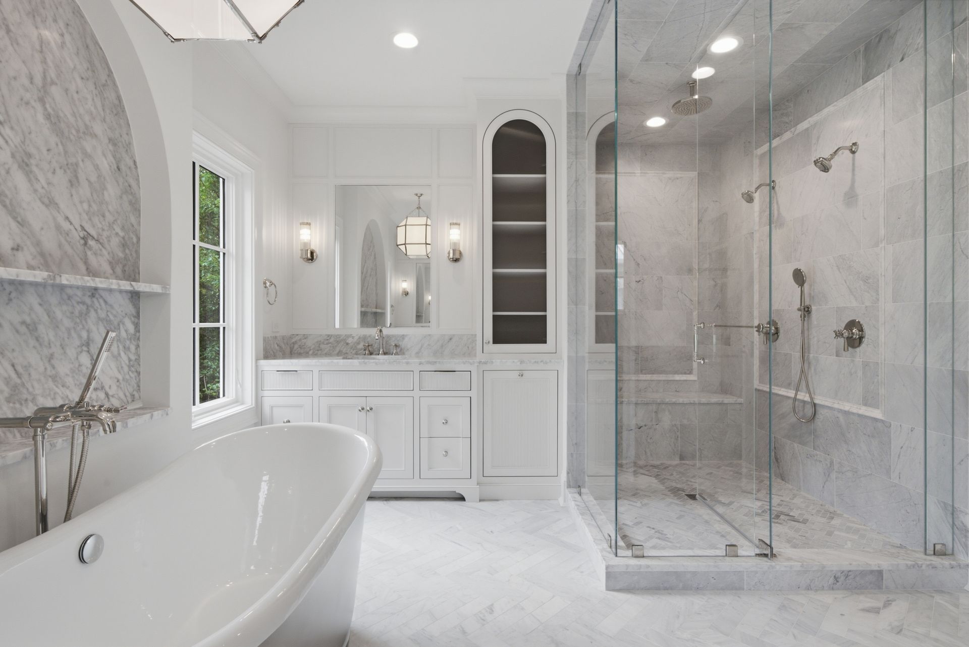 Bright modern white bathroom with a freestanding tub, glass shower, and double vanity