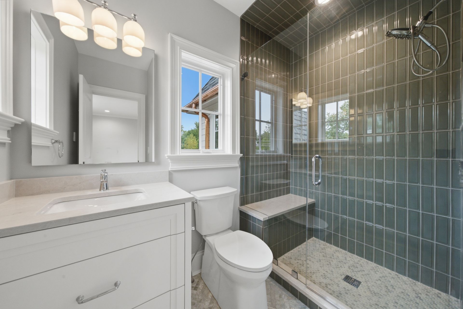Modern bathroom with white vanity, toilet, and glass-enclosed tiled shower