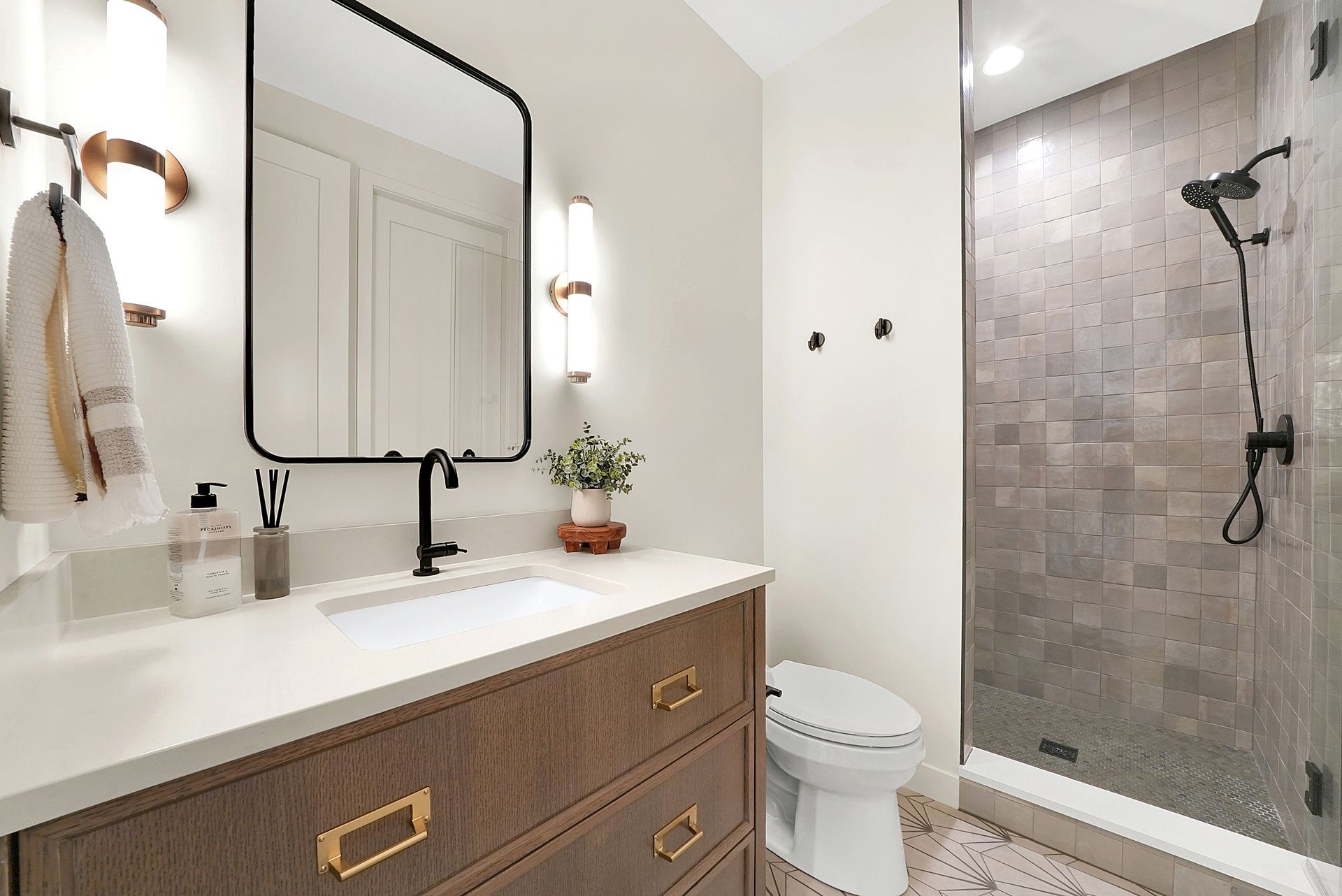 Modern bathroom with vanity, mirror, toilet, and tiled walk-in shower
