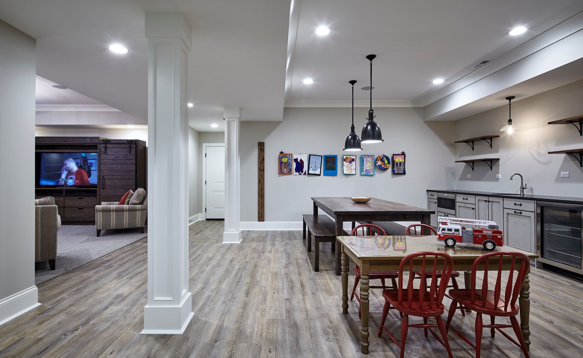 Open-concept basement with kitchen, dining table, and living area with TV and couch