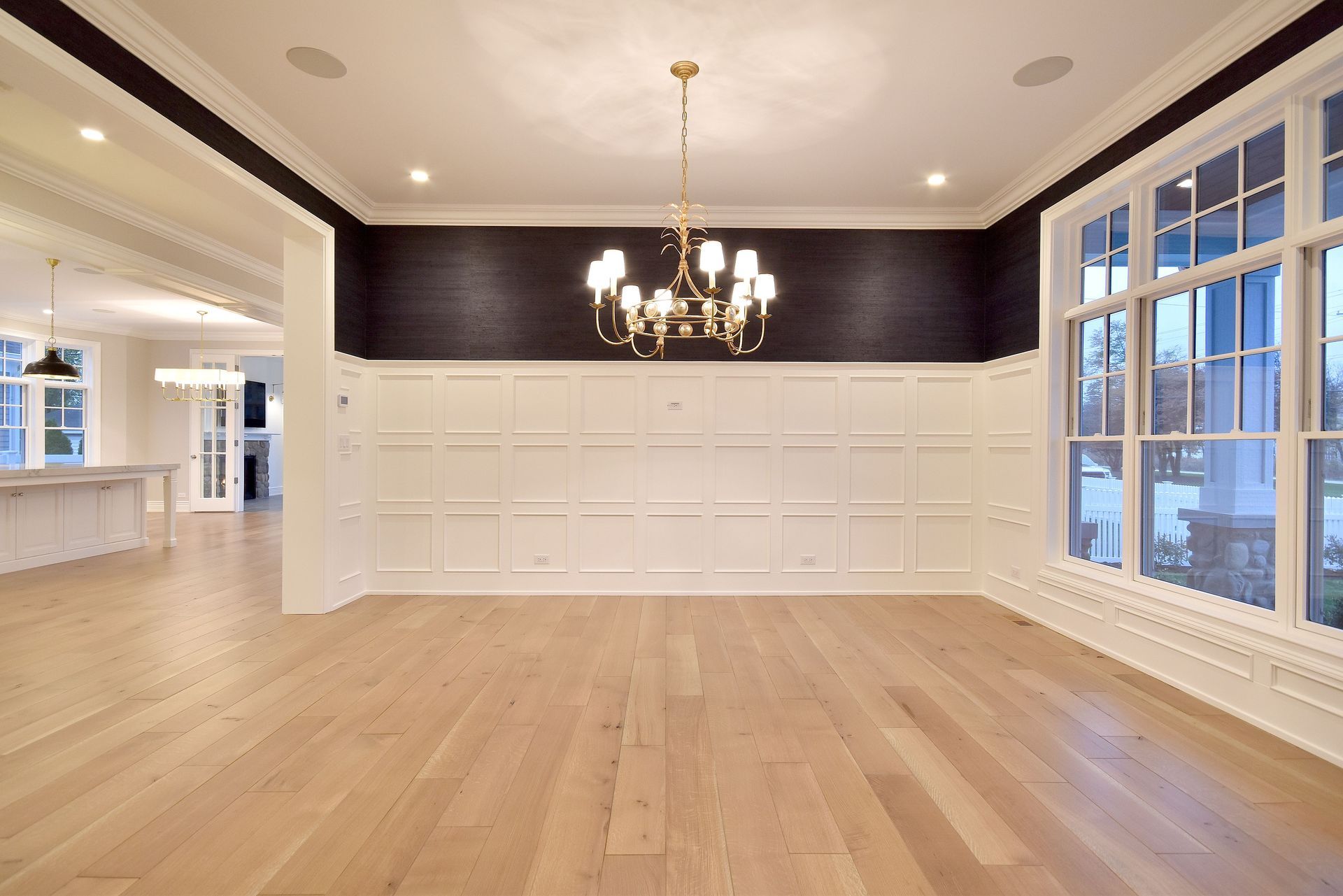 Empty formal dining room with hardwood floors, chandelier, and large windows