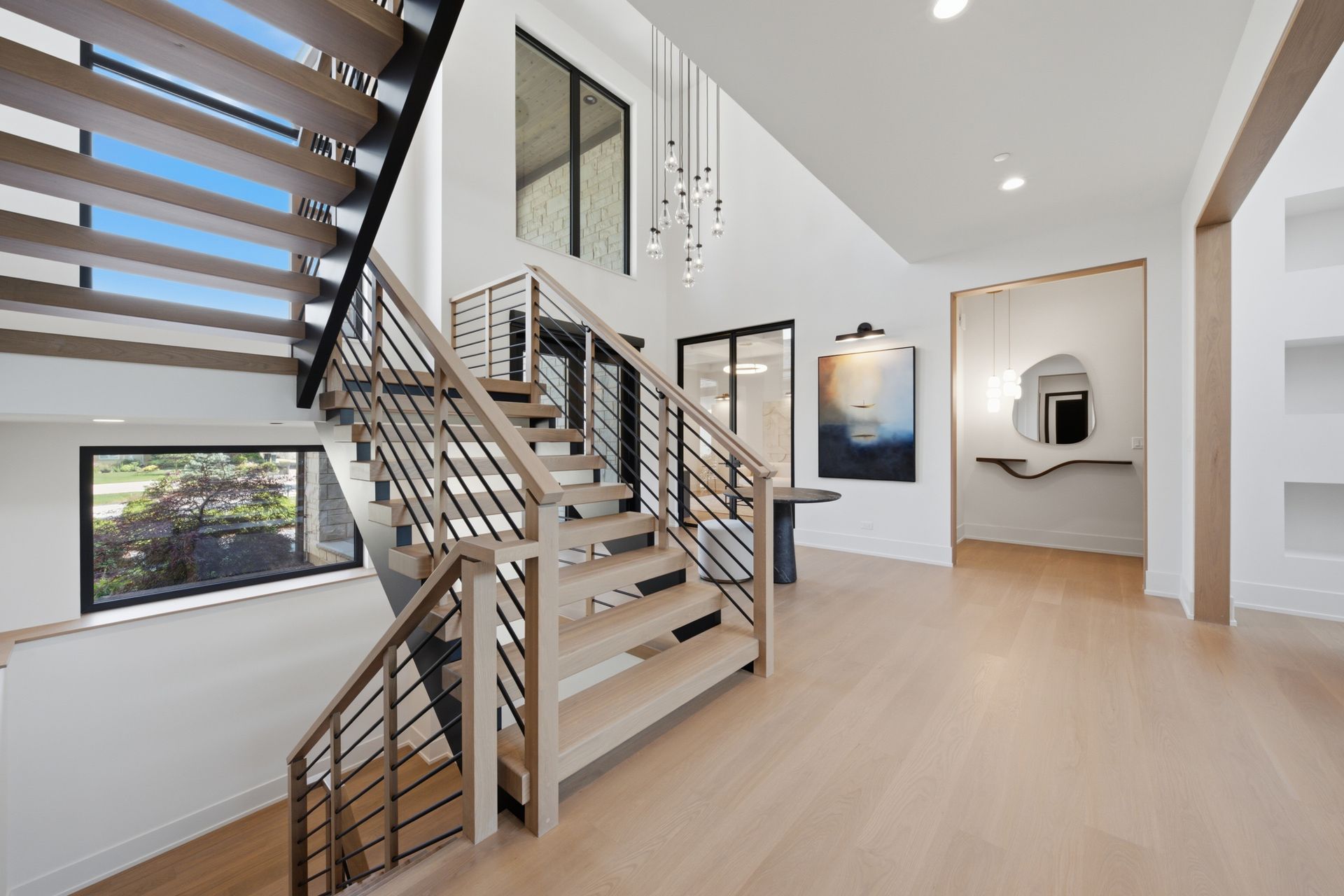 Modern staircase in a bright open home with wood floors and large windows