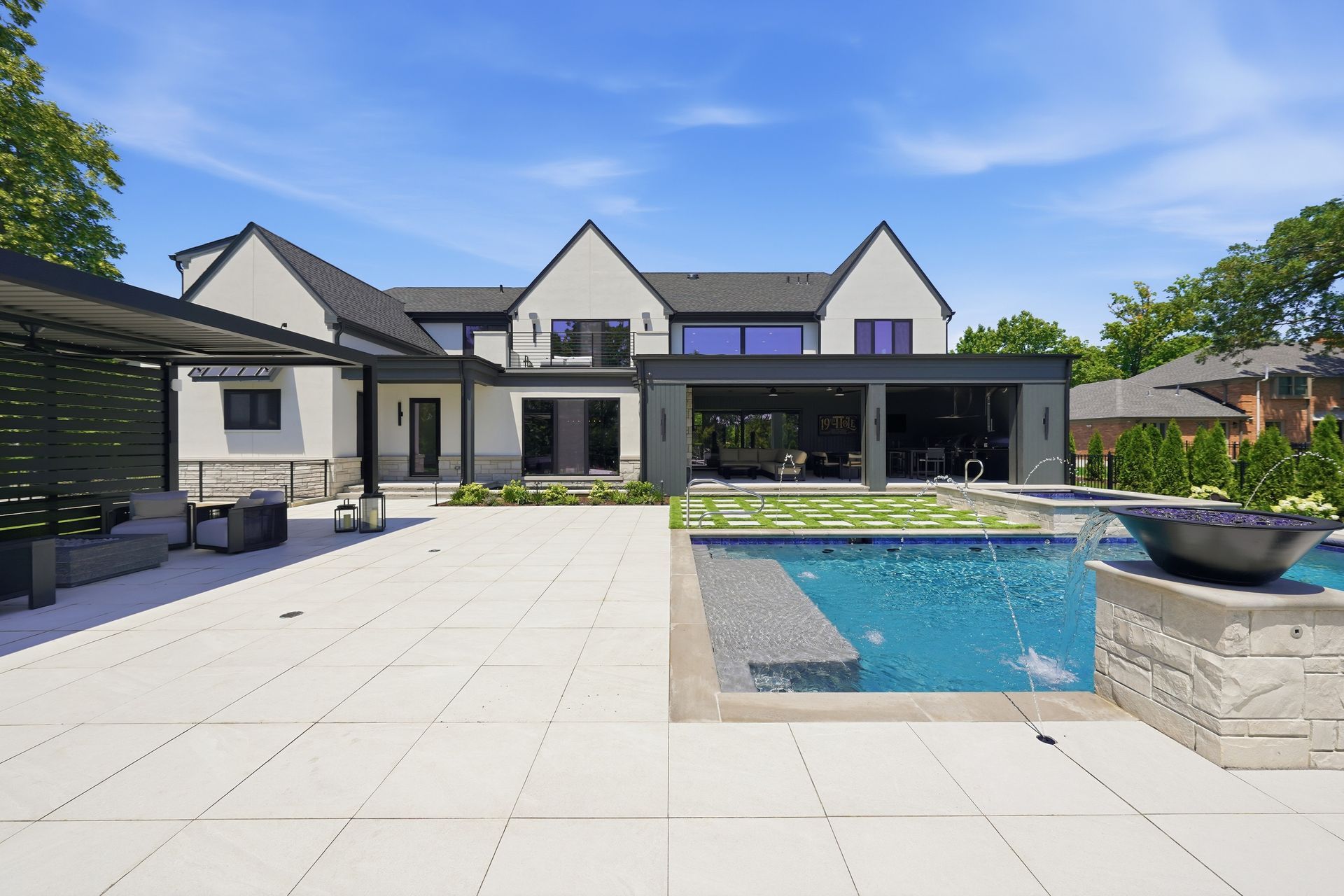 Modern house with large patio and swimming pool under a clear blue sky