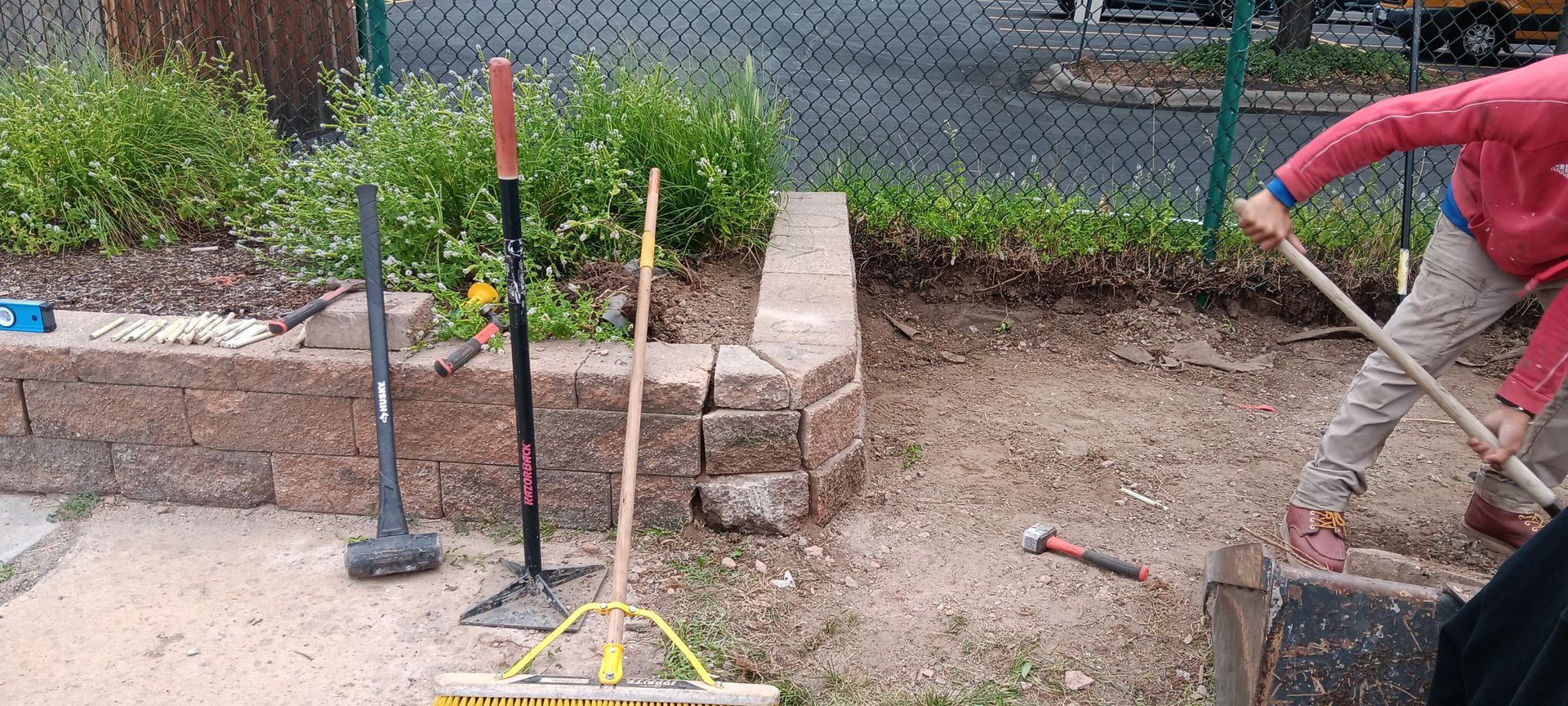 A person is holding a shovel in a garden.