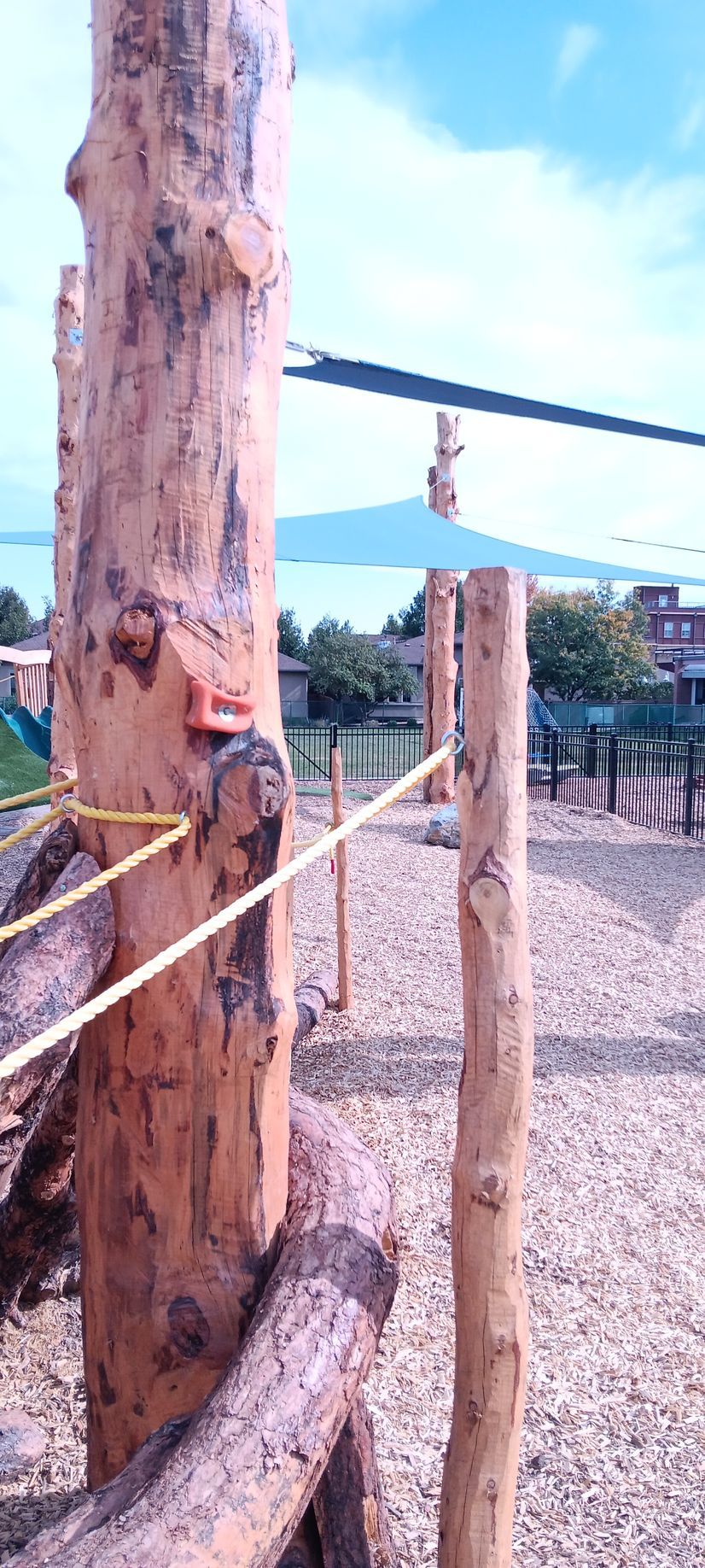 A tree stump is sitting in the middle of a playground.