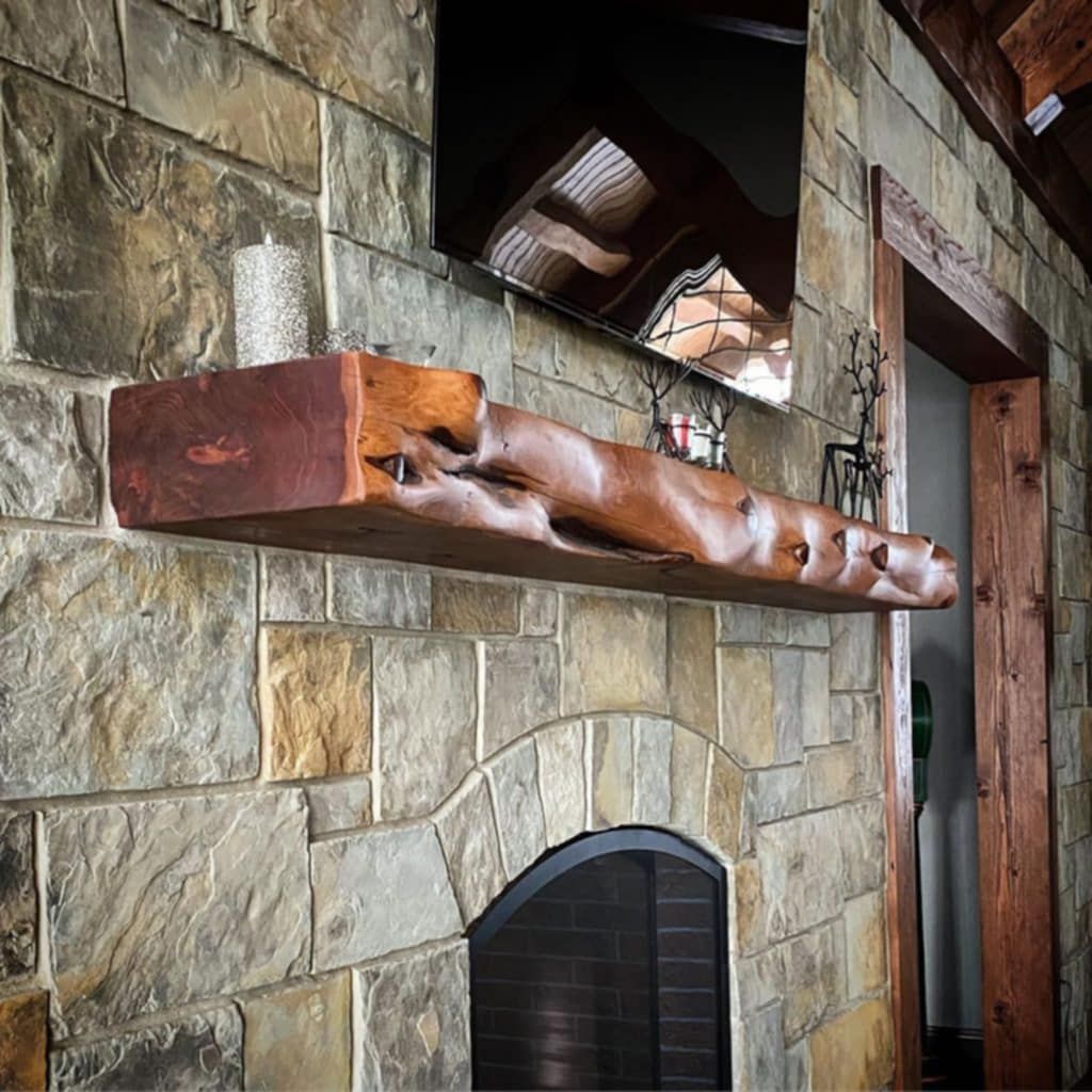 A fireplace with a wooden mantle and a tv above it