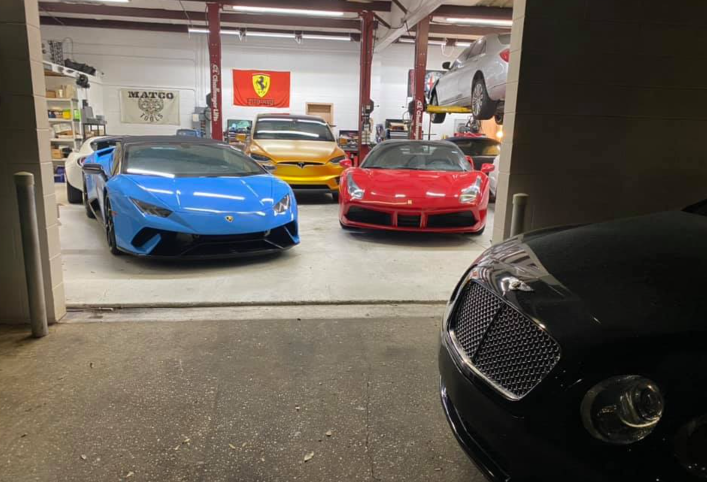 A group of sports cars are parked in a garage.
