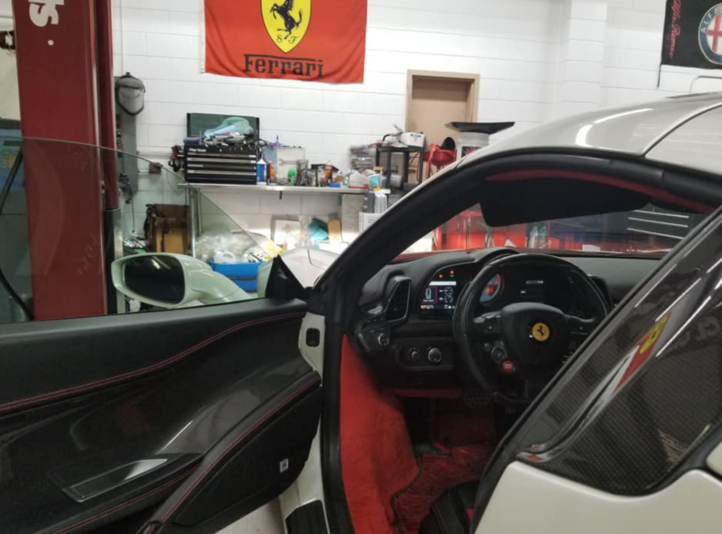 A ferrari car is parked in a garage with the door open
