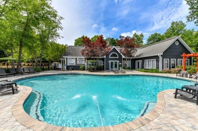 a large pool with a house in the background