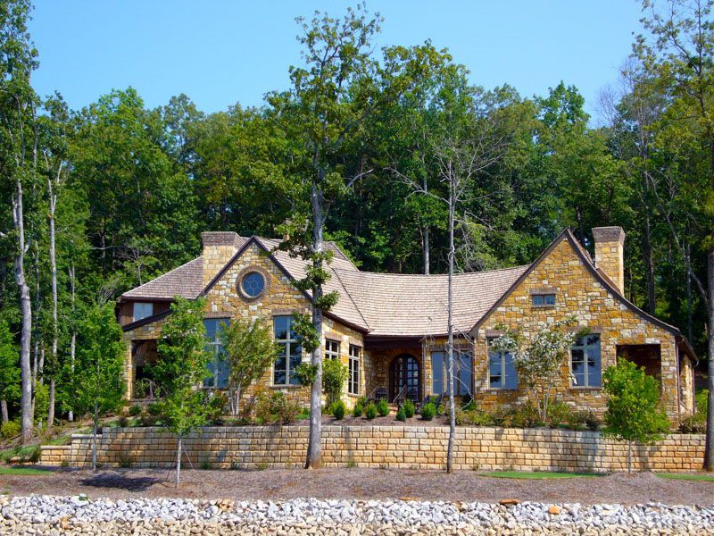 A large house is surrounded by trees and rocks