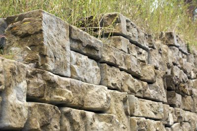 A close up of a stone wall in a field.