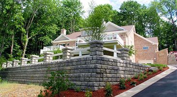 A large house with a stone wall in front of it