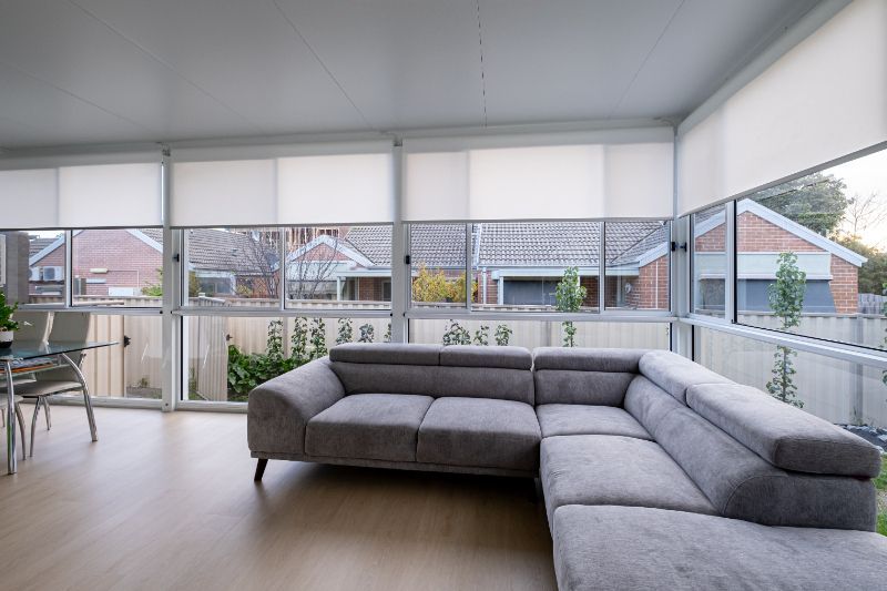 a living room with a couch and lots of windows versatile roller shades in Love is Blinds Tucson