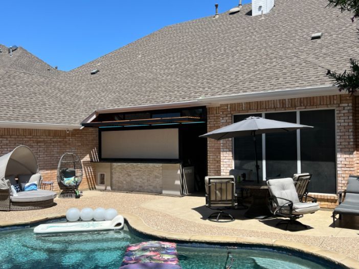 An outdoor pool setting has a section of privacy with patio shades.