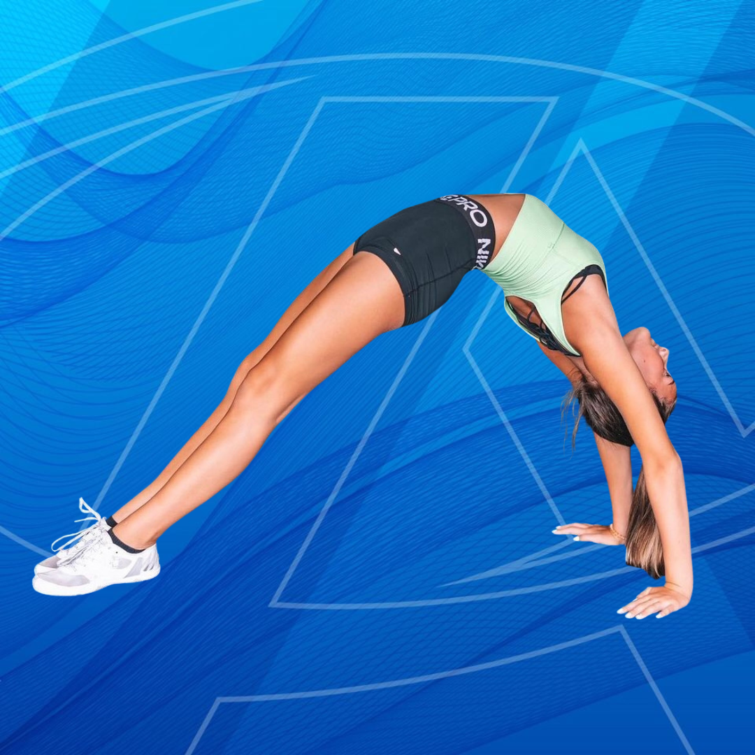 A young girl is standing on a balance beam in a gym.