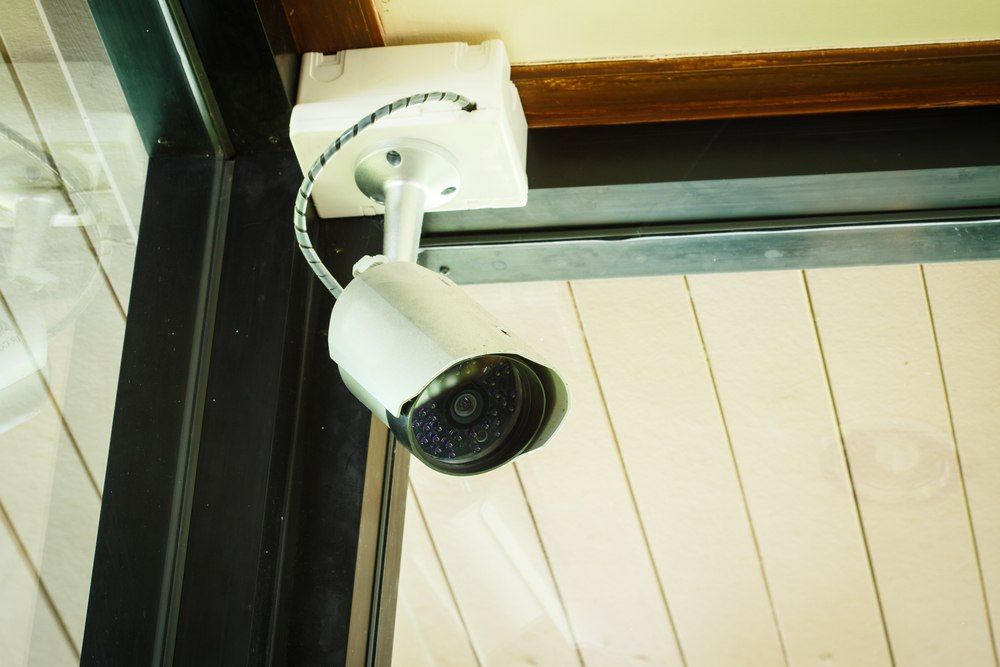 Security Camera Mounted On A White Ceiling, Near A Black Door Frame — Aliance Group in Grafton, NSW