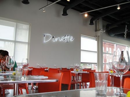A restaurant with a neon sign that says dinette