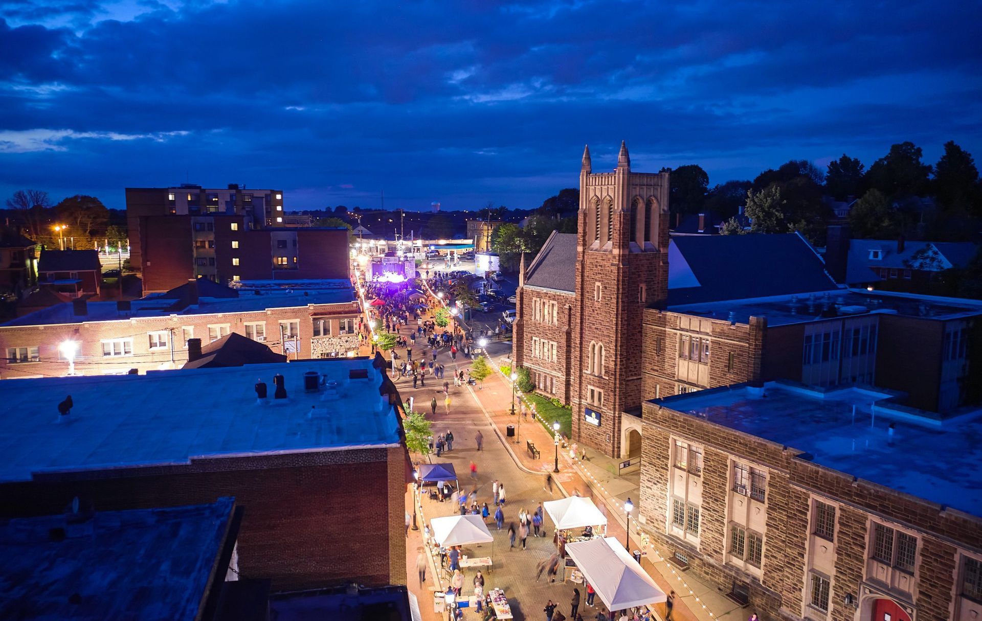 An aerial view of a city at night with a church in the background