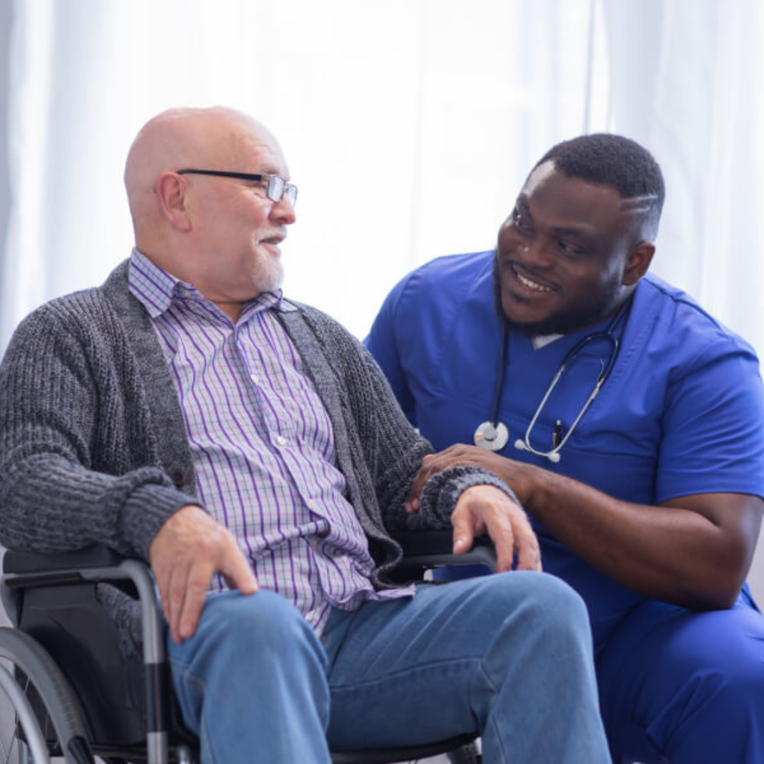A man in a wheelchair is talking to a nurse