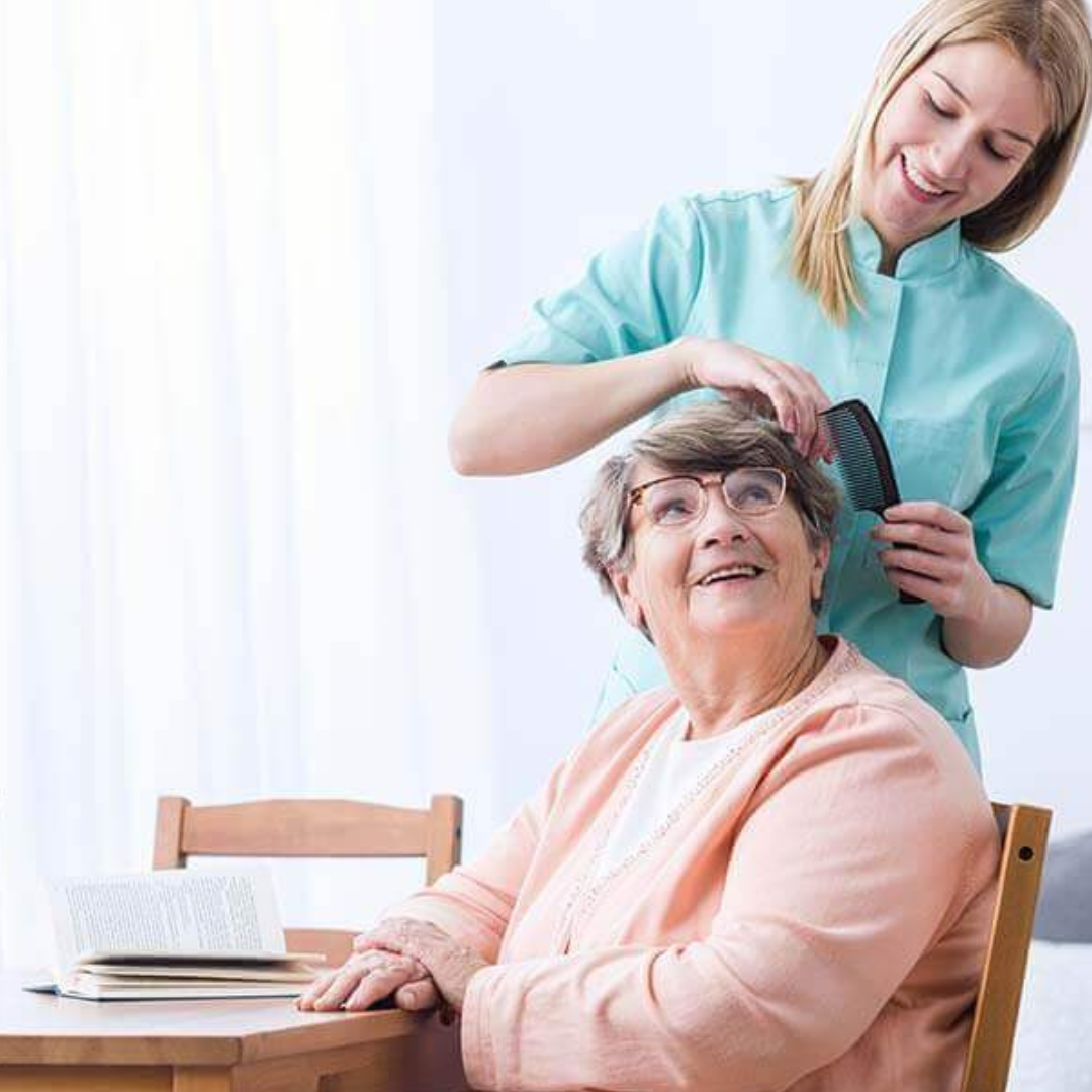 A woman is brushing another woman 's hair while sitting at a table.