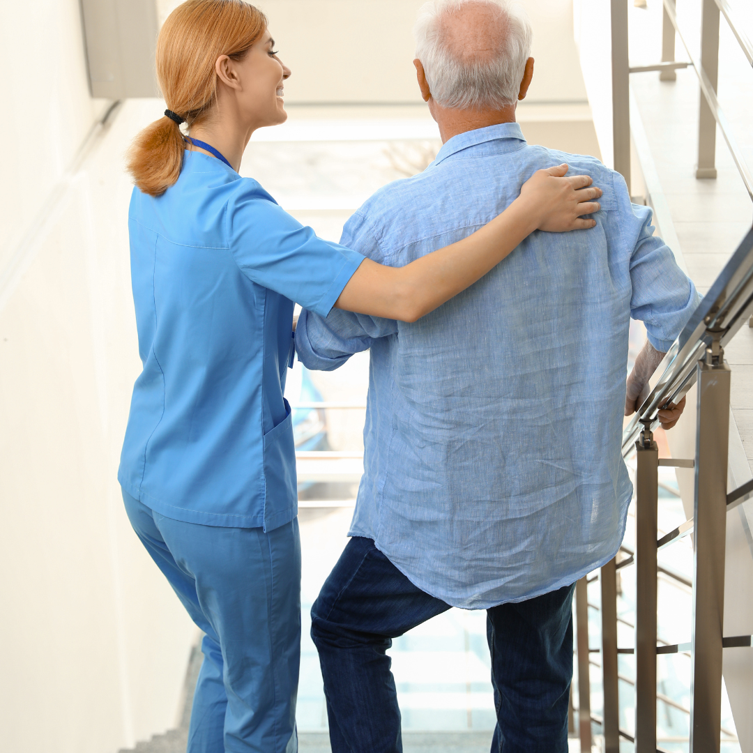 A nurse is helping an elderly man walk up the stairs.