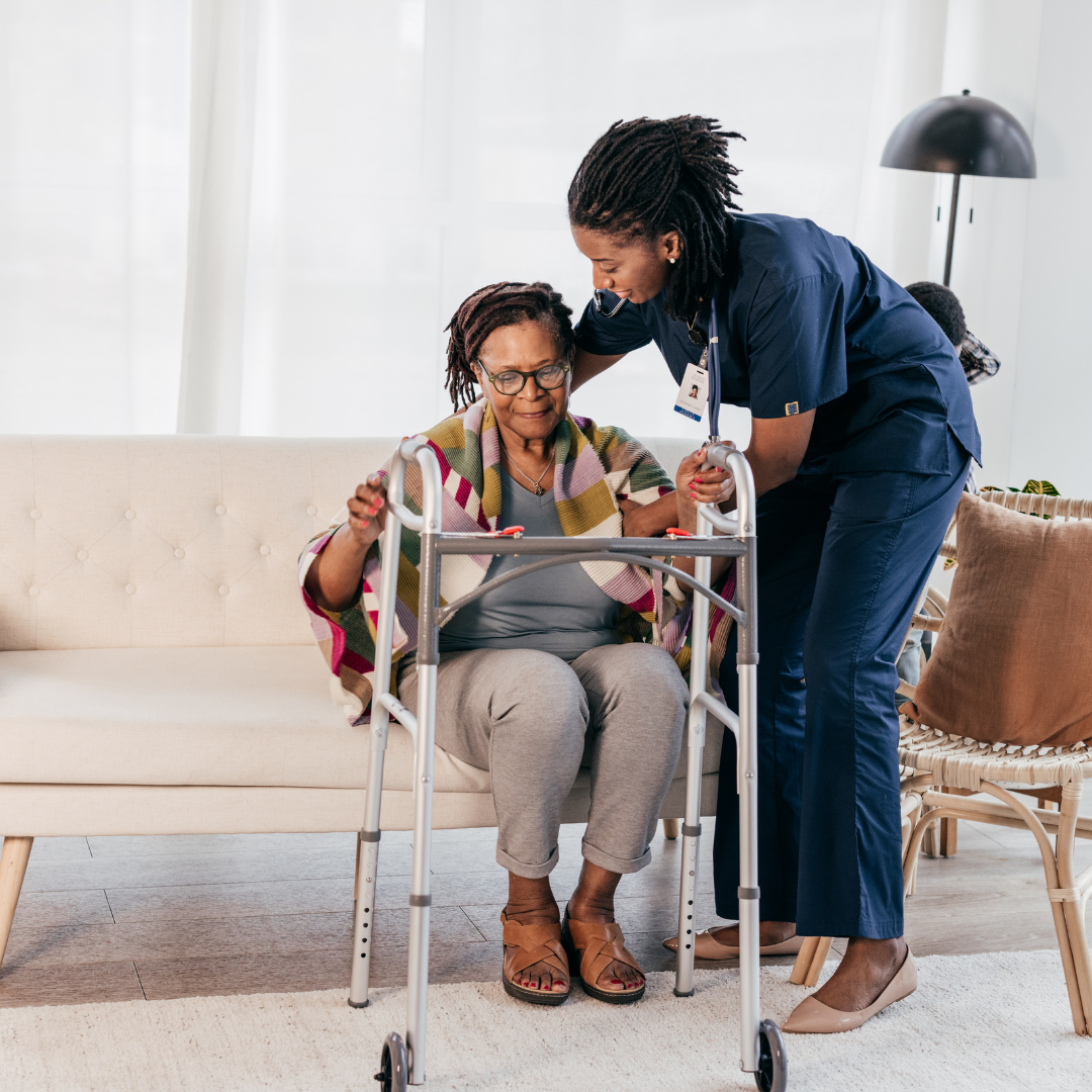 A nurse is helping an elderly woman use a walker.