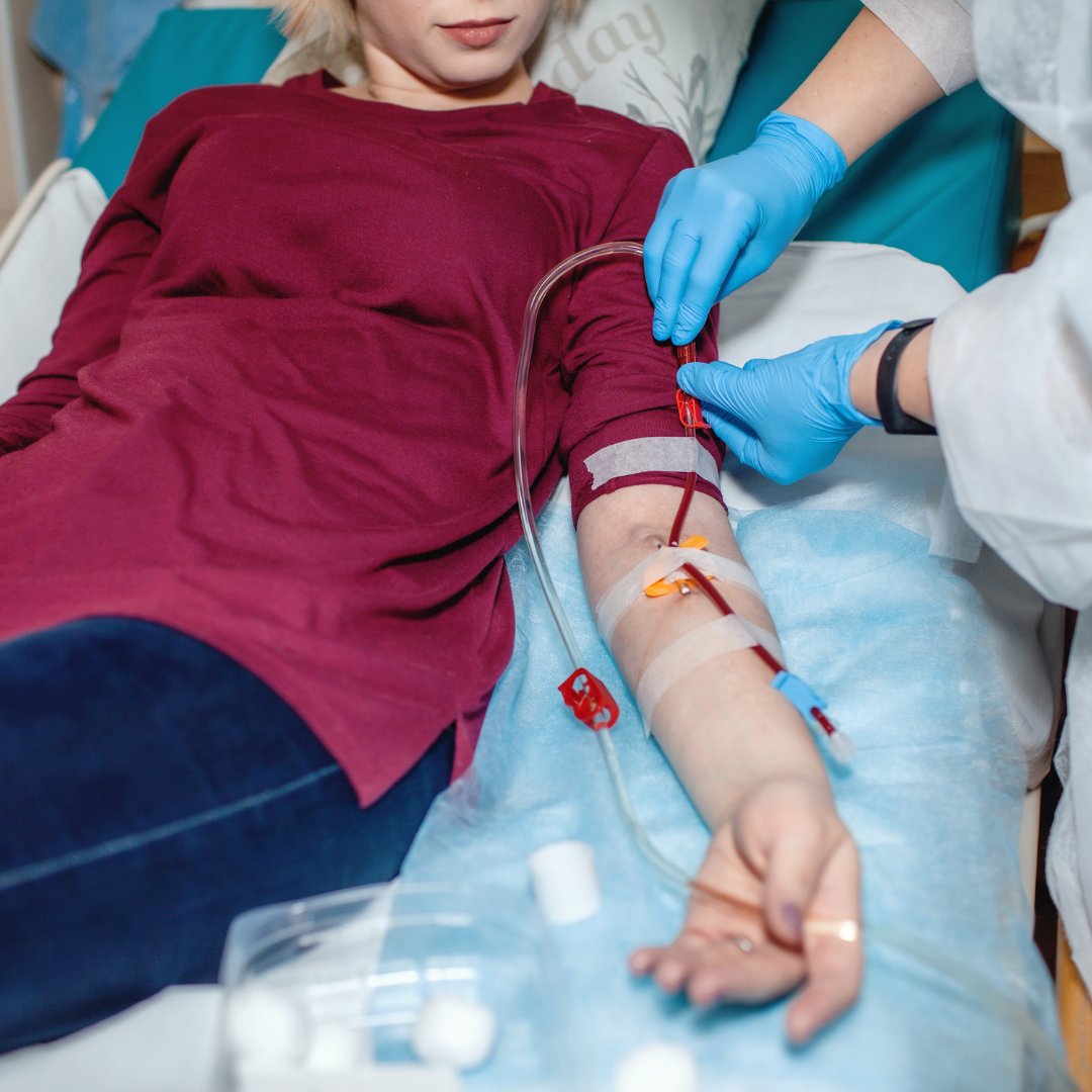 A woman is laying in a hospital bed with an iv in her arm