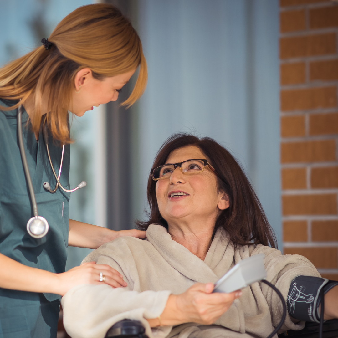 A woman in a wheelchair is talking to a nurse