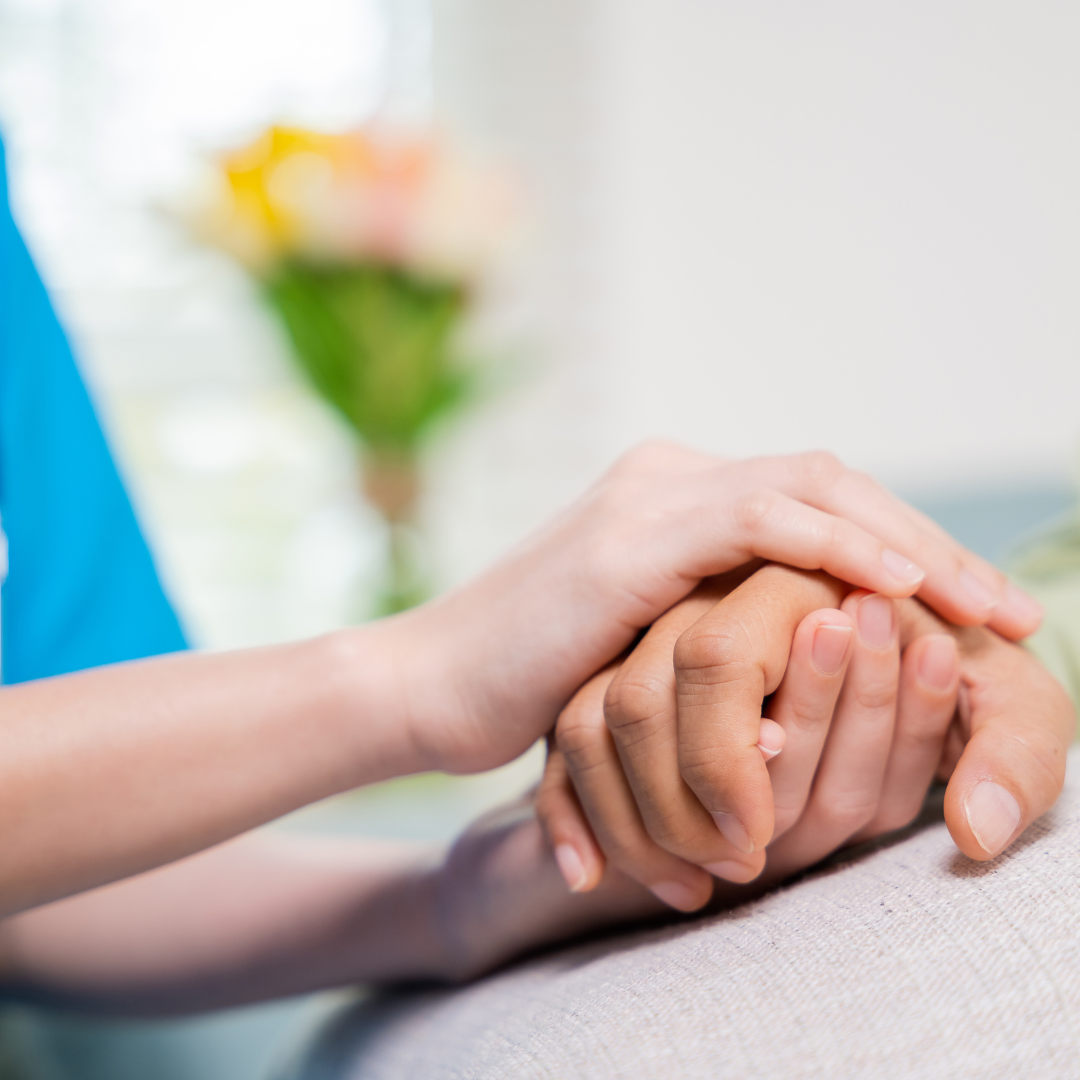 A close up of a person holding another person 's hand.