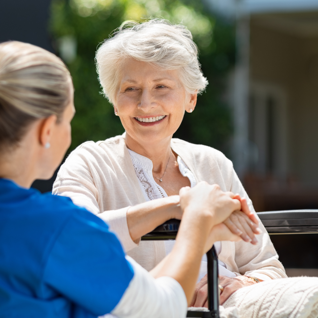A nurse is talking to an elderly woman in a wheelchair.