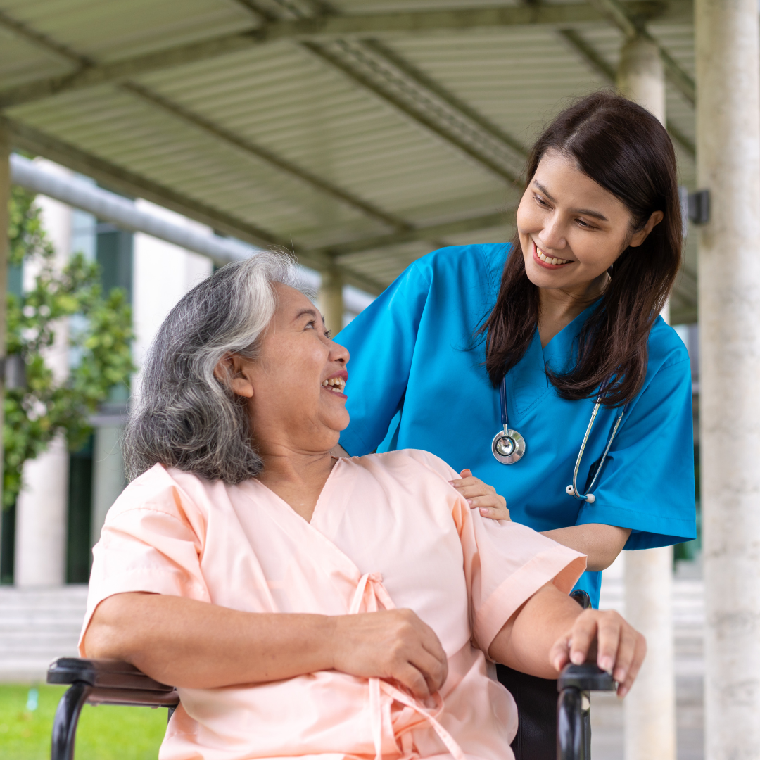 A nurse is talking to an elderly woman in a wheelchair.