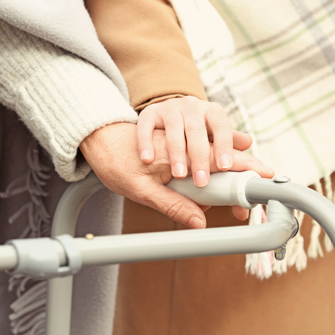 A person holding another person 's hand while using a walker