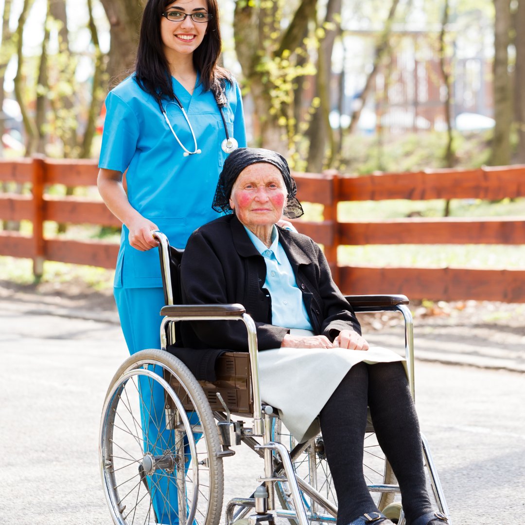 A nurse pushes an elderly woman in a wheelchair