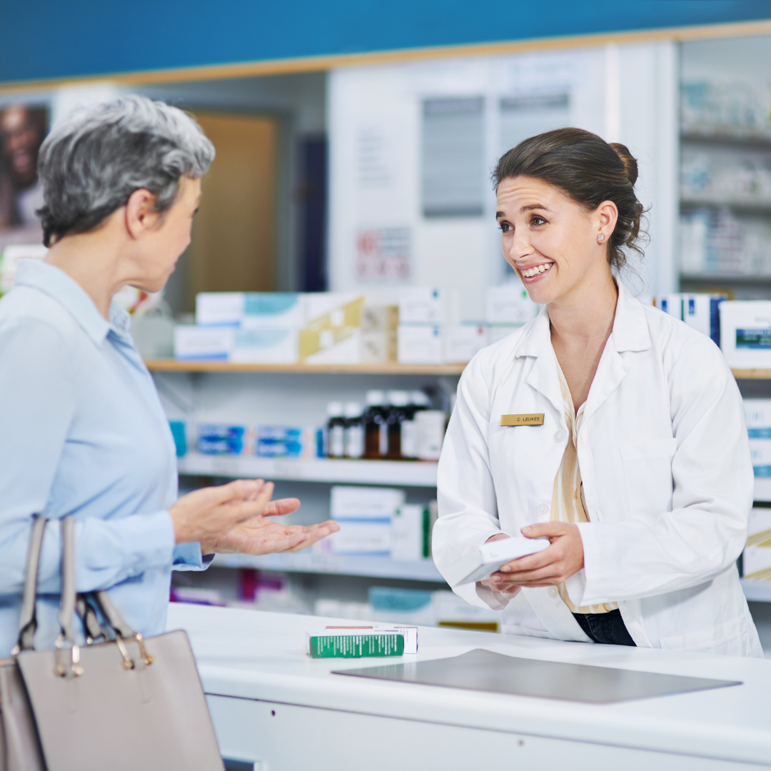 A woman is talking to a pharmacist in a pharmacy.
