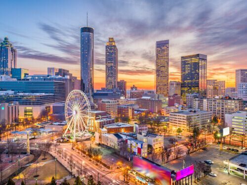 An aerial view of a city with a ferris wheel in the middle of it.
