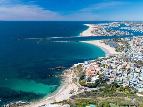 An aerial view of a beach with a city in the background.