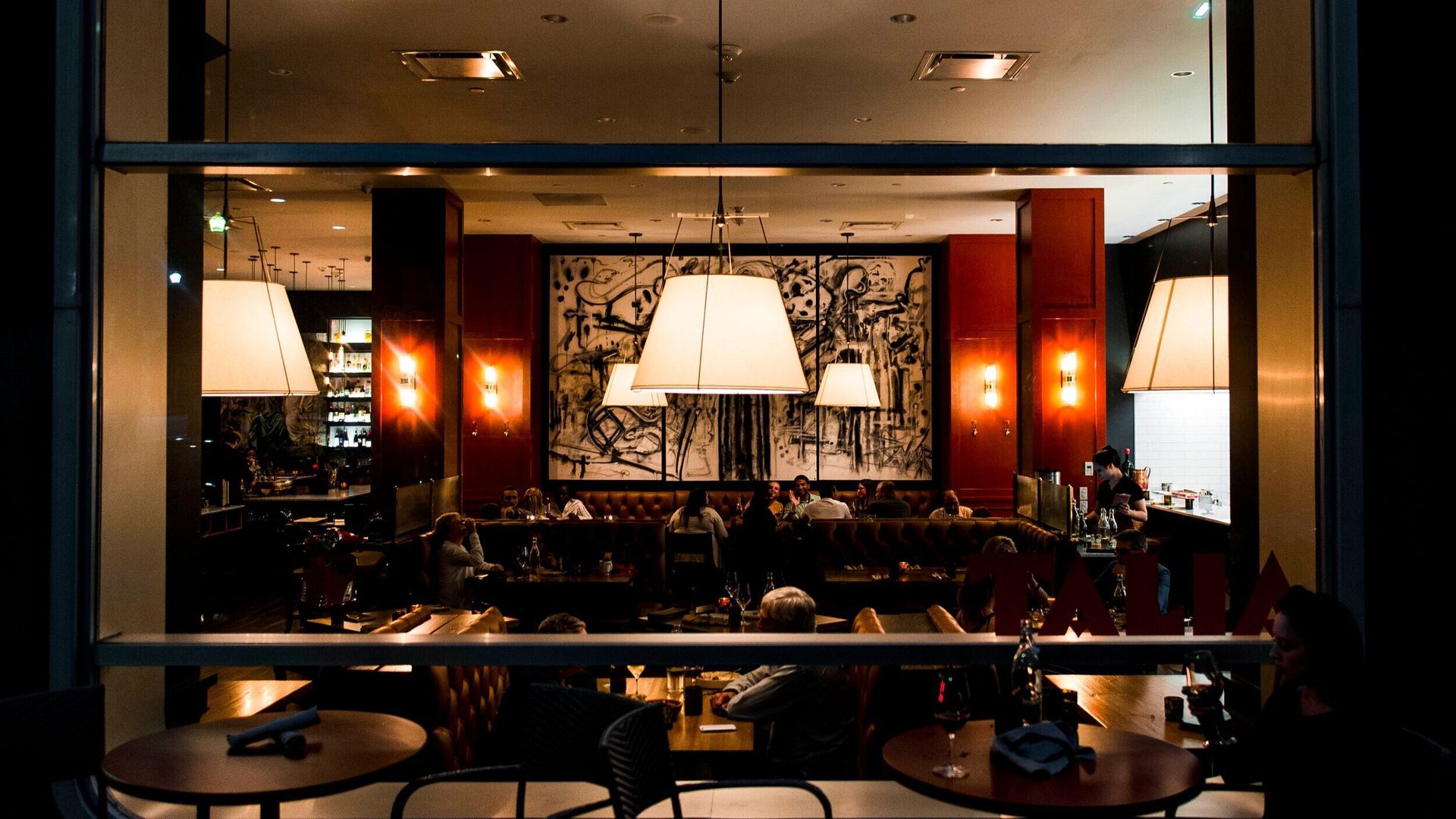 A view of a restaurant through a window at night