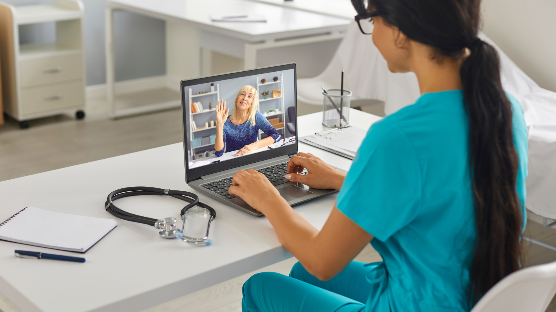 Young Doctor Sitting and Working on Laptop Online in Medical Clinic