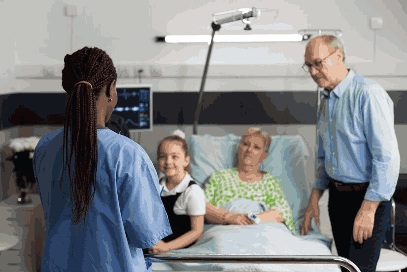 A nurse is talking to a patient in a hospital bed.